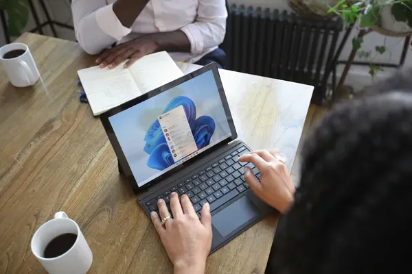 Réunion de travail en PME avec ordinateur portable et outils collaboratifs Microsoft 365